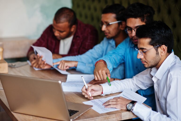 Group of four south asian men's posed at business meeting in caf