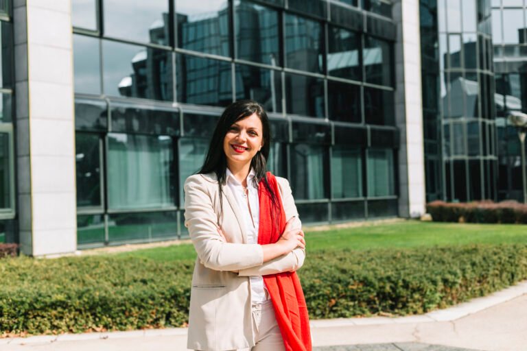 portrait-happy-businesswoman-with-crossed-arms-front-building
